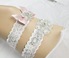 "--Rhinestone Wedding Garter, Crystal Garter Set,Off White Lace band Bridal Garter, Wedding Garter, Keepsake and Toss Garter Set-GT005 -- Beautiful custom sized bridal garters made with off white lace and clear crystal rhinestones in silver color settings . The keepsake applique is measured at 2\"width and 5\"long. The toss garter is 5/8\"width and 3\" long satin bow . These garters will be a stunning addition for your special day! Sample is an off-white stretch lace. Lace width: 1 1/2\" keepsak Adjustable Bridal Accessories With Rhinestones, Adjustable Rhinestone Bridal Accessories, White Rhinestone Bridal Accessories For Ceremony, White Bridal Accessories With Rhinestones For Ceremony, Elegant Pink Bridal Belt For Wedding, Elegant Pink Bridal Set For Wedding, Adjustable Rhinestone Bridal Accessories For Wedding, Adjustable Silver Bridal Accessories For Marriage, White Bridal Sets