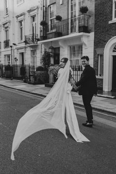 a bride and groom walking down the street