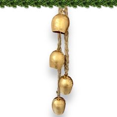 an ornament hanging from a christmas tree with three bells on it's side