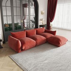 a large red couch sitting on top of a rug