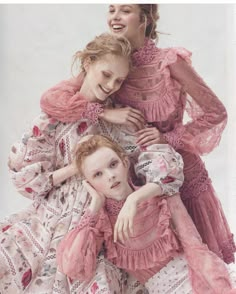 two girls in pink dresses hugging each other