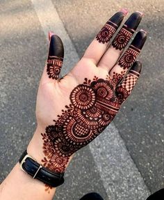 a woman's hand with henna tattoos on it