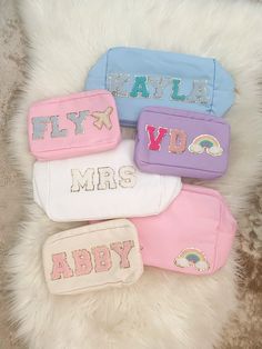 four personalized makeup bags sitting on top of a fur rug