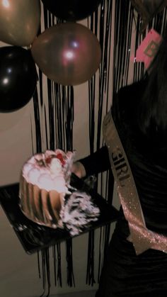 a woman is holding a cake with white frosting and pink icing on it