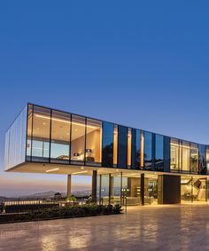 a large glass building with lots of windows on it's sides at night time