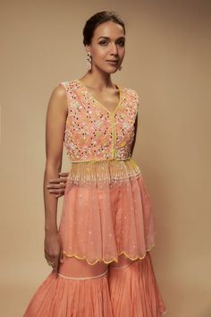 Peach peplum tunic embellished by sequin bead floral motifs on yoke and pearl tassels. Comes with pearl lined tiered gharara. - Aza Fashions Pearl Tassels, Tunic Pattern, Beaded Neckline, Floral Peplum, Sequin Beading, Floral Motifs, Aza Fashion, Fashion Set, Floral Motif