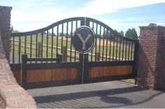 a gate with a sign that says y on it and some brick pillars in the background