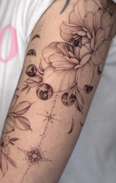 a woman's arm with flowers and stars on it