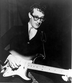 a black and white photo of a man playing an electric guitar