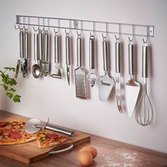 a pizza sitting on top of a wooden cutting board next to utensils and spatulas