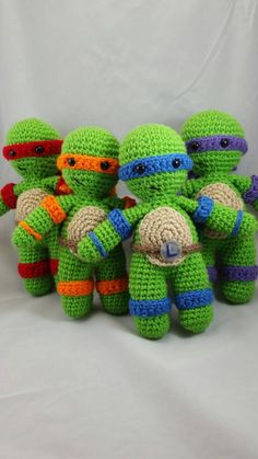 four crocheted teenage mutants sitting next to each other