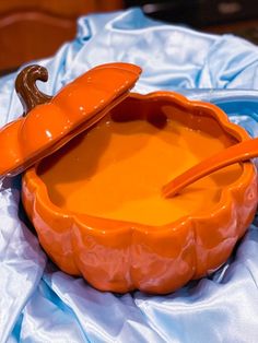 an orange pumpkin shaped bowl with a spoon in it