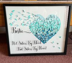 a framed sign with butterflies in the shape of a heart and saying, best sisters by heart