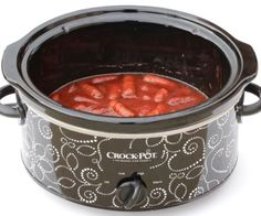 a crock pot filled with red beans on top of a white table