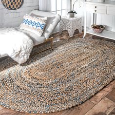 a living room area with a rug on the floor and white furniture in the background