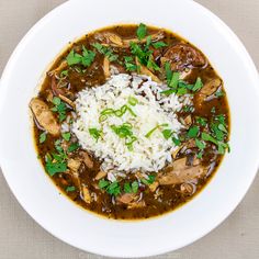 a white bowl filled with rice and mushroom soup on top of a tablecloth covered table