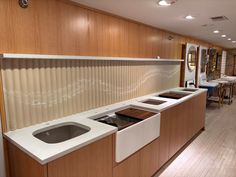 an empty kitchen with wooden cabinets and white counter tops, along with tables and chairs