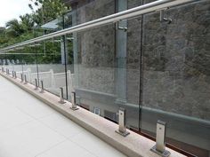 there are many glass railings on the side of this building that is made of stone and steel