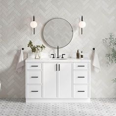 a white bathroom with two sinks and a round mirror on the wall next to plants