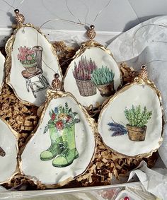 six ornaments in a box with flowers and plants painted on them, including green boots