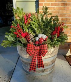 a wooden bucket filled with christmas decorations and greenery