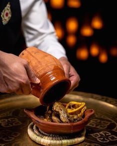 a person pouring some food into a bowl