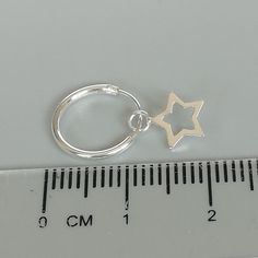 A PAIR of sterling silver hoops. Comes with a detachable tiny and delicate star charm. The charm is multipurpose and can be used with a neck or bracelet chain too. Dimension: Hoop- 12 x 1.2 mm Charm- 6 x 6 mm Weight: 0.97 gm Price listed is for a PAIR of hoops. These earrings are made of 925 hypoallergenic sterling silver and comes with a 925 stamp. Can be packaged in a gift box. I can include a personal message from you if needed You are welcome to contact me at... bhavnakwintra1956@gmail.com F Silver Huggie Earrings With Charms In Small Hoop Shape, Sterling Silver Star Cartilage Earring, Sterling Silver Star Charm Huggie Earrings, Sterling Silver Star Charm Cartilage Earrings, Sterling Silver Star Cartilage Earrings With Star Charm, Silver Star-shaped Sterling Silver Hoop Earrings, Silver Minimalist Huggie Earrings With Charms, Sterling Silver Hoop Earrings With Star Charm For Gift, Nickel Free Star Shaped Silver Cartilage Earrings