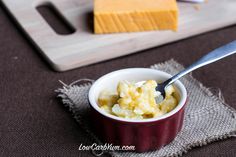 there is a small bowl of food on the table with cheese and butter in it