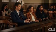 three people sitting in chairs at a church