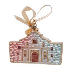 a ceramic ornament with a ribbon around it's neck and an image of a house on the front