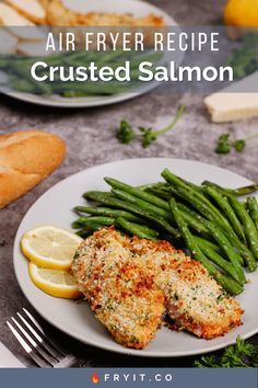 two plates with chicken, green beans and lemon wedges on them next to breaded baguettes