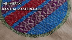 a close up of a circular object on a table cloth with the words, meme merak kantha master class