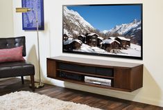 a flat screen tv sitting on top of a wooden entertainment center in a living room