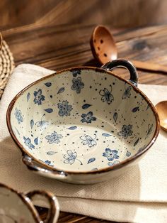 a blue and white bowl sitting on top of a table next to wooden spoons