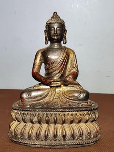 a buddha statue sitting on top of a wooden table