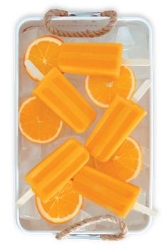 orange slices are arranged on sticks in an ice tray