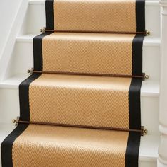 a set of stairs with black and tan carpet