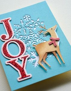 a close up of a christmas card with a reindeer and snowflakes on it