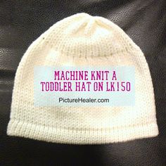 a white knitted hat with the words machine knit a toddler hat on it