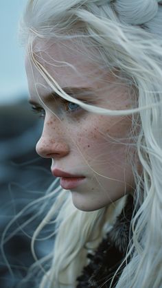 a woman with long white hair and blue eyes