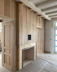 an unfinished room with wood paneling and exposed lighting