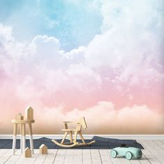 two wooden rocking chairs sitting on top of a floor next to a wall with clouds in the background