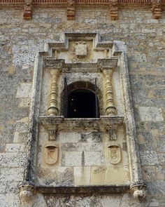 an old stone building with a clock on it's face and window sill