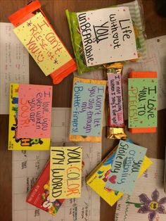 some candy bars that are sitting on top of a table with notes attached to them