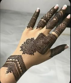 a woman's hand with henna tattoos on it