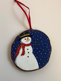 a wooden ornament with a snowman painted on it