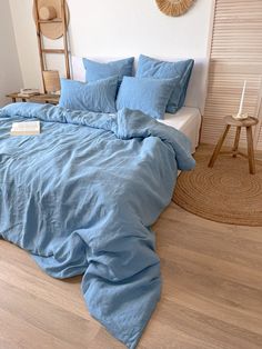 a bed with blue sheets and pillows in a room