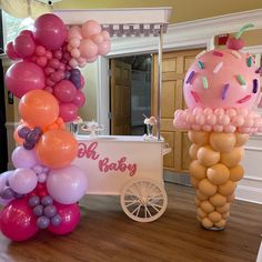 an ice cream cart is decorated with balloons and other decorations for a birthday party or baby shower