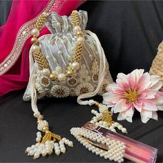 Silver Potli Bag For Bride, Beaded Purse For Wedding Day Bag For Mother Of Groom Gift Proposal Bag For Bridesmaid. The Drawstring Bag Comes In 3 Colors Baby Pink, Silver And Gold. Please Choose Your Color In The Options. Our Baby Pink, Silver And Gold Beaded And Zardozi Work Potli Is A Stunning And Functional Accessory That Can Be Used To Stylishly Carry Your Essentials. The Potli Is Made Of Silk Fabric. The Beaded And Zardozi Work Is Elaborated And Detailed, Adding A Glamorous Touch To The Potl Embroidered Fabric Embellished For Navratri Wedding, Embroidered Fabric Embellished For Wedding And Navratri, Wedding Embellished Embroidered Fabric For Navratri, Embellished Embroidered Fabric For Wedding, Elegant Pearl Embroidered Fabric For Celebration, Festive Silver Embellished Embroidered Fabric, Bollywood Style Embellished Bags For Wedding, Elegant Pink Embroidered Fabric For Navratri, Festive Beaded Embroidered Fabric For Party