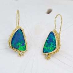 Escape into the beauty of the sea with these stunning Opal & Diamond Earrings. Crafted from 18K granulated gold and adorned with gorgeous blue-green opals and two small diamonds, these earrings shimmering like the rolling waves of a distant shore. Treat yourself to a little oasis with these charming ocean-inspired earrings 18KY granulated earrings with 2 opal doublets weighing 8.42cts and accented with .06cttw of VS/GH diamonds.Dimensions: 7/8” x 9/16” (24mm x 15mm) excluding earwire Yellow Gold Opal Gemstone Earrings, Ocean Inspired Earrings, Ocean Inspired, Green Opal, Vintage Jewels, Ocean Inspiration, Boulder Opal, The Sea, Oasis